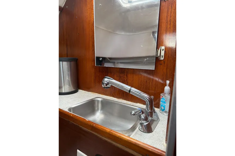 Slide: The Image of 1989 Gemini 3000 boat interior sink with faucet, mirror, and hand sanitizer. - 9