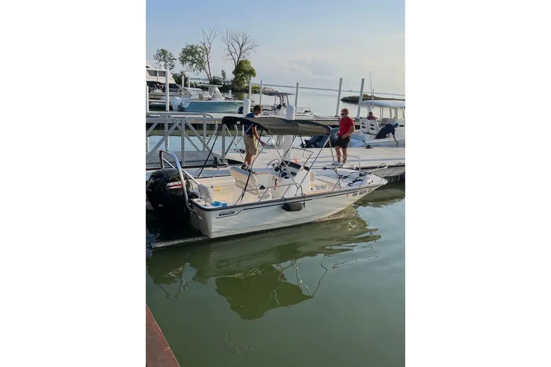 Slide: The Image of 2020 Boston Whaler 170 Montauk docked at marina with people onboard. - 10
