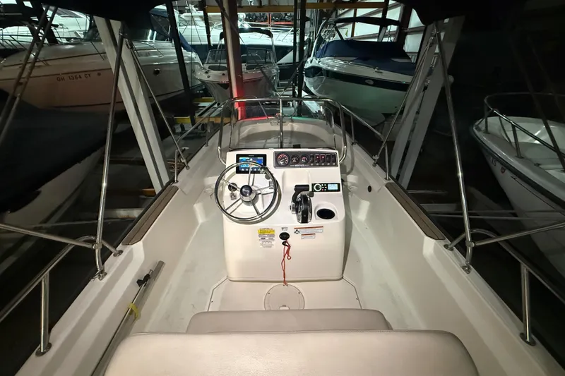 Slide: The Image of 2020 Boston Whaler 170 Montauk boat interior with steering console in marina setting. - 18