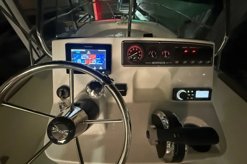 Slide: The Image of 2020 Boston Whaler 170 Montauk dashboard with steering wheel and navigation controls. - 19