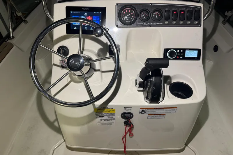 Slide: The Image of 2020 Boston Whaler 170 Montauk boat dashboard with steering wheel and control panel. - 28