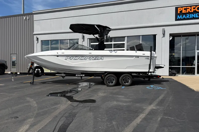 Slide: The Image of 2025 Moomba Makai boat on trailer outside marine dealership. - 2