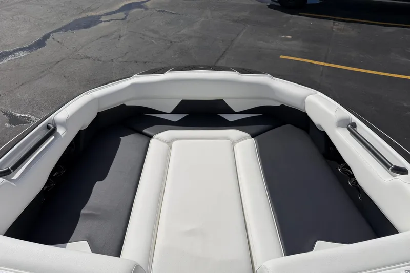 Slide: The Image of 2025 Moomba Makai boat interior with white and gray seating, parked on asphalt. - 27