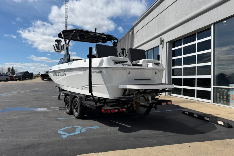 Slide: The Image of 2025 Moomba Makai boat on trailer outside dealership under blue sky. - 4