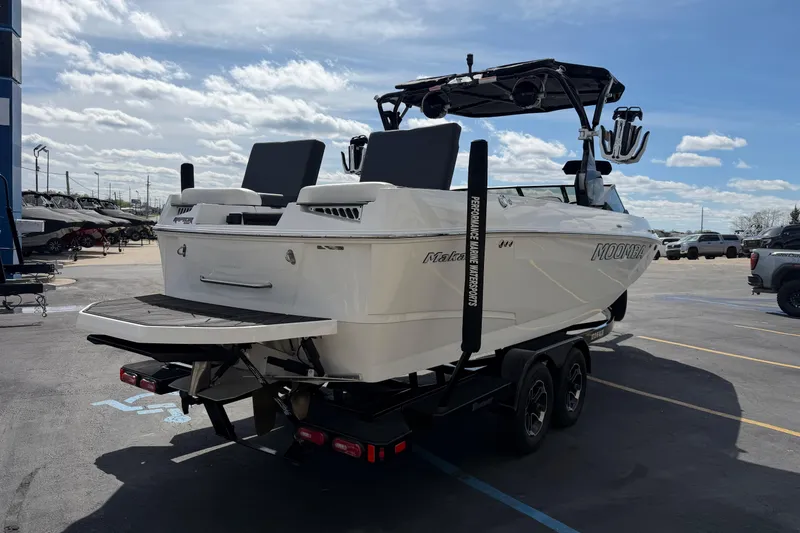 Slide: The Image of 2025 Moomba Makai boat on trailer, parked outdoors under a partly cloudy sky. - 6