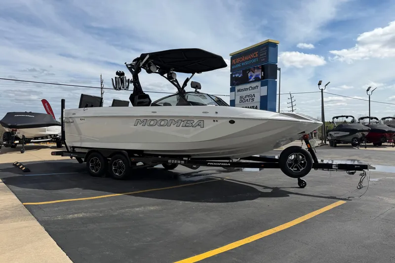 Slide: The Image of 2025 Moomba Makai boat on trailer at dealership under blue sky. - 7