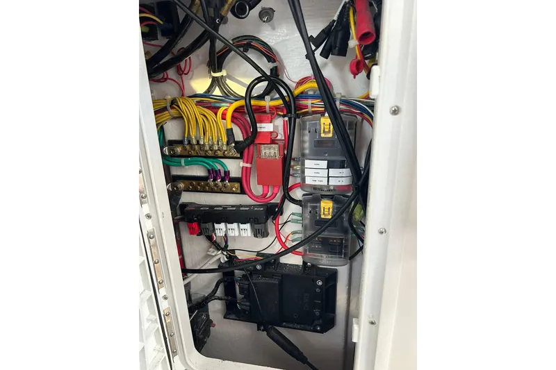 Slide: The Image of Electrical wiring panel inside 2024 NorthCoast 235 HT boat, showcasing organized cables and connectors. - 10