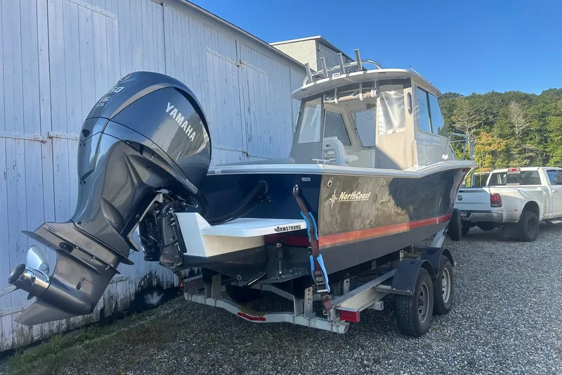 Slide: The Image of 2024 NorthCoast 235 HT boat with Yamaha engine on trailer, parked outdoors. - 2