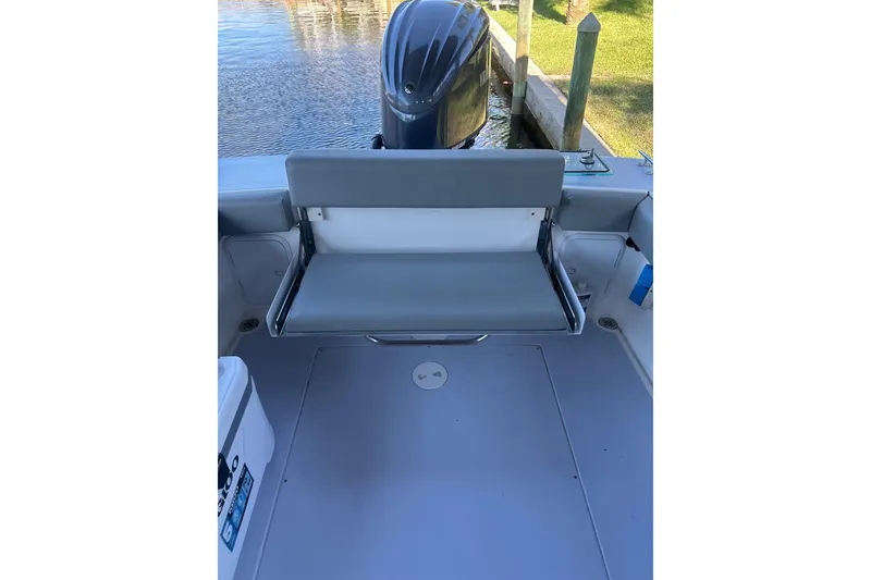 Slide: The Image of 2024 NorthCoast 235 HT boat interior with foldable seating and outboard motor view. - 6
