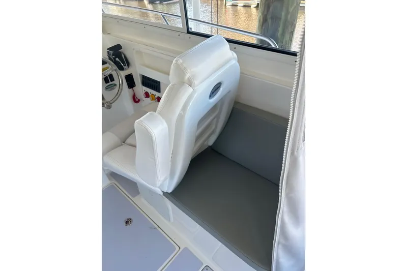Slide: The Image of 2024 NorthCoast 235 HT boat interior with white seating and steering wheel. - 8