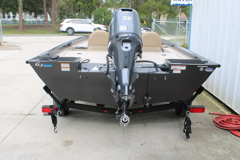Slide: The Image of 2025 G3 Sportsman 1610 boat with outboard motor on trailer, parked outdoors. - 8