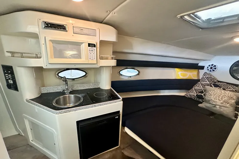 Slide: The Image of 2001 Rinker Fiesta Vee 270 cabin interior with kitchenette and cozy seating area. - 10