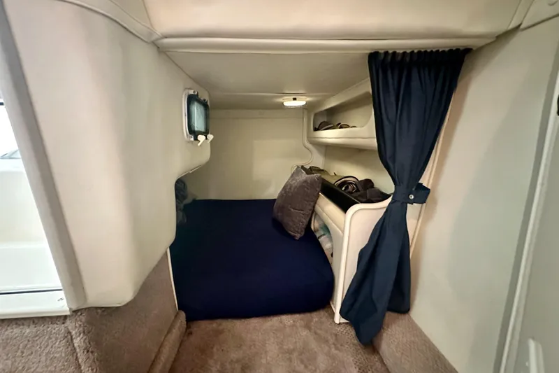 Slide: The Image of 2001 Rinker Fiesta Vee 270 cabin interior with cozy bed and storage shelves. - 11