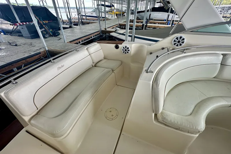 Slide: The Image of 2001 Rinker Fiesta Vee 270 boat interior with white seating and dock view. - 17