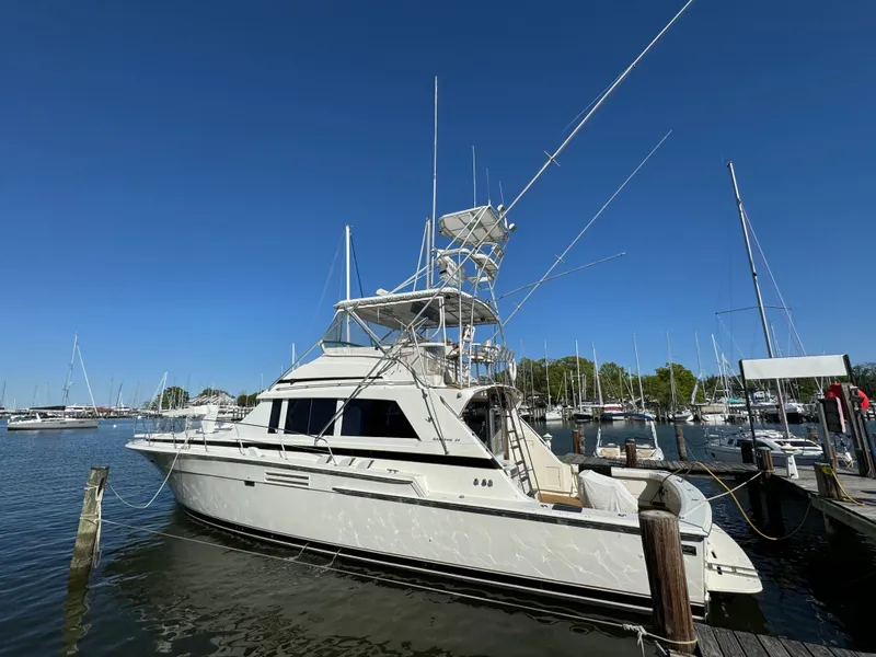 Slide: The Image of 1986 Bertram 54 Convertible Yacht docked in marina under clear sky. - 21