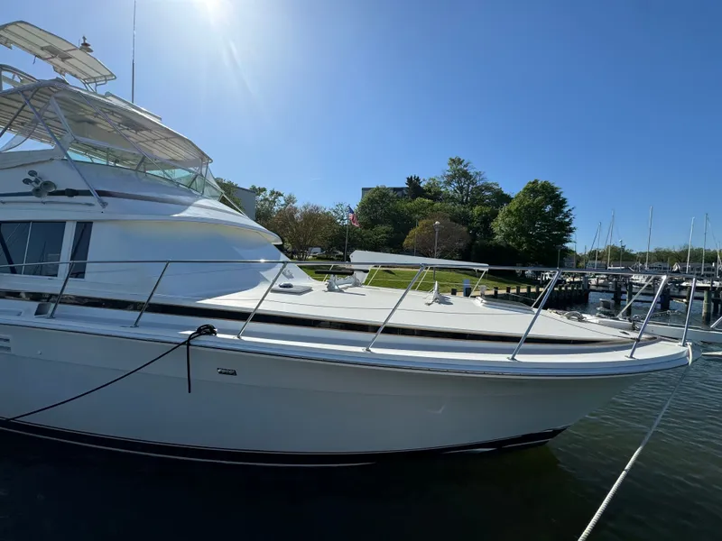 Slide: The Image of 1986 Bertram 54 Convertible yacht docked under sunny skies. - 25