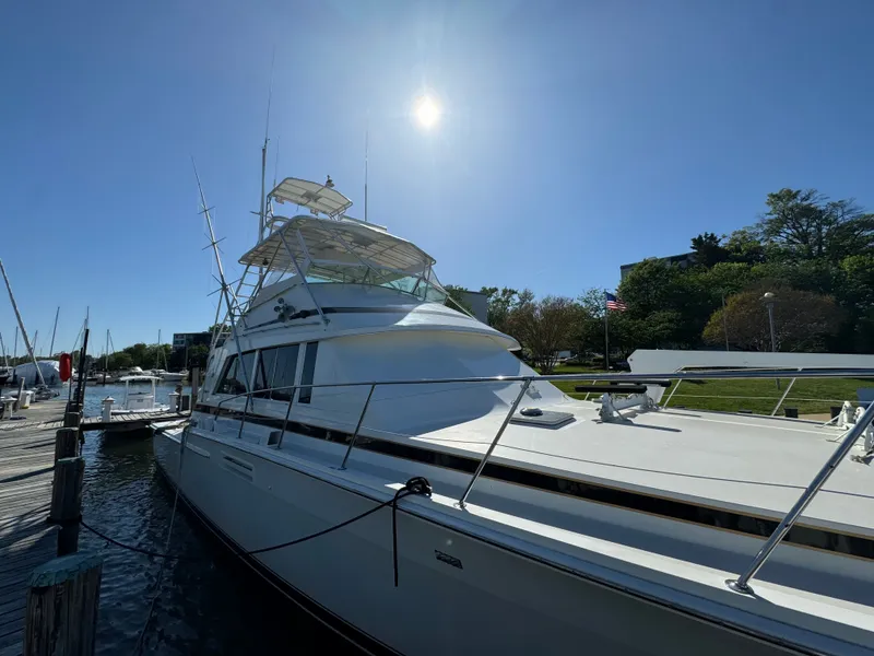 Slide: The Image of 1986 Bertram 54 Convertible yacht docked under sunny skies. - 26