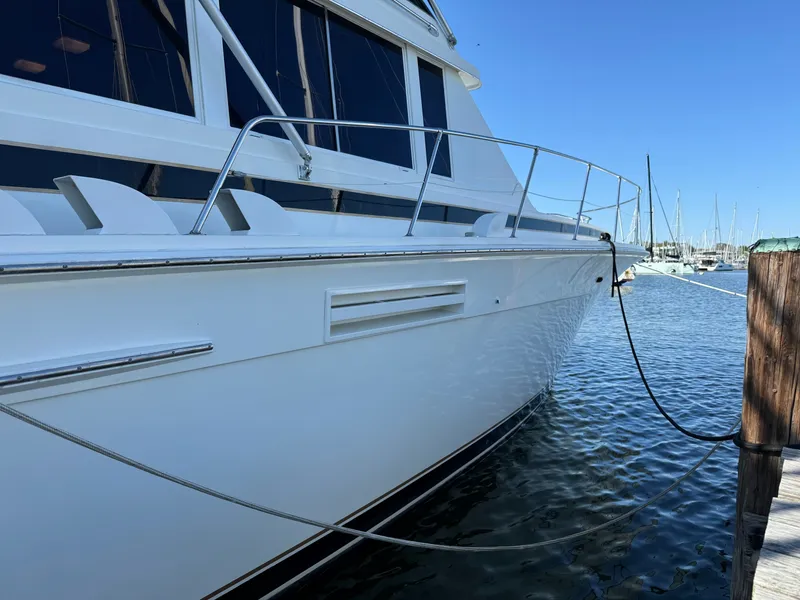 Slide: The Image of 1986 Bertram 54 Convertible yacht docked, calm waters. - 27