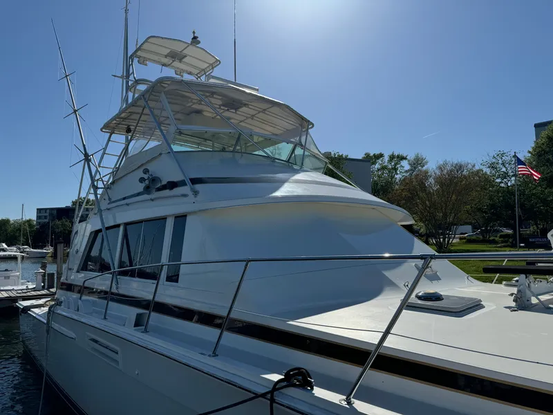 Slide: The Image of 1986 Bertram 54 Convertible yacht docked under sunny skies. - 28