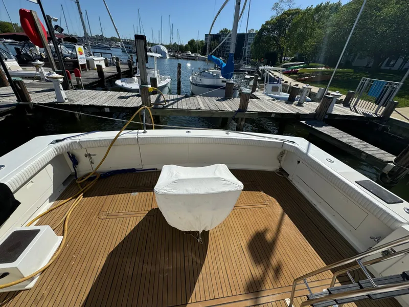 Slide: The Image of 1986 Bertram 54 Convertible at dock, featuring wooden deck. - 29