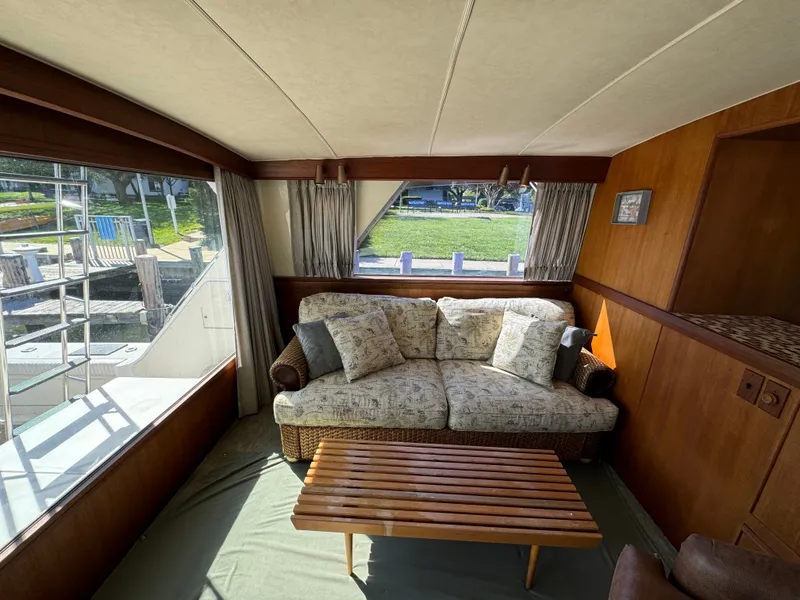 Slide: The Image of Interior of a 1986 Bertram 54 Convertible yacht with sofa and wooden table. - 34
