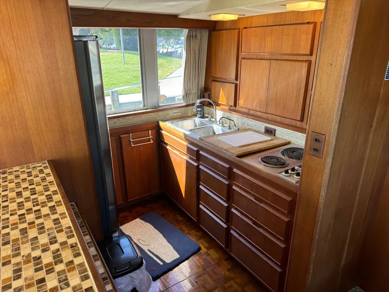 Slide: The Image of 1986 Bertram 54 Convertible boat kitchen with wooden cabinets and stove. - 41