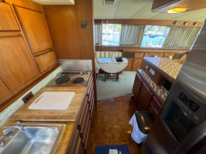 Slide: The Image of Interior of 1986 Bertram 54 Convertible yacht, featuring kitchen and dining area. - 44
