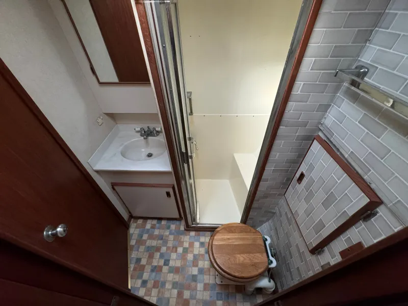 Slide: The Image of 1986 Bertram 54 Convertible bathroom with shower and wooden toilet seat. - 46