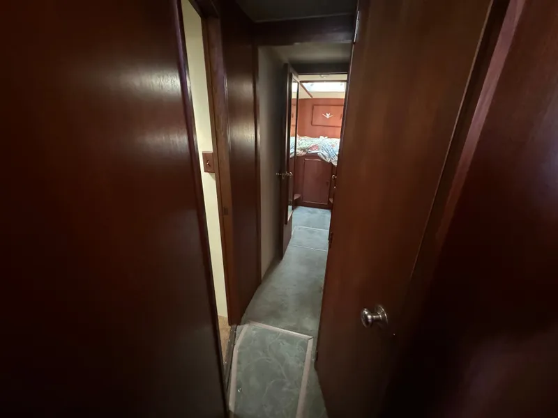 Slide: The Image of Interior of a 1986 Bertram 54 Convertible, featuring wooden doors and carpeted floor. - 48