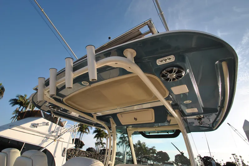 Slide: The Image of 2021 Grady-White Canyon 336 boat with rod holders and speakers, under a clear blue sky. - 14