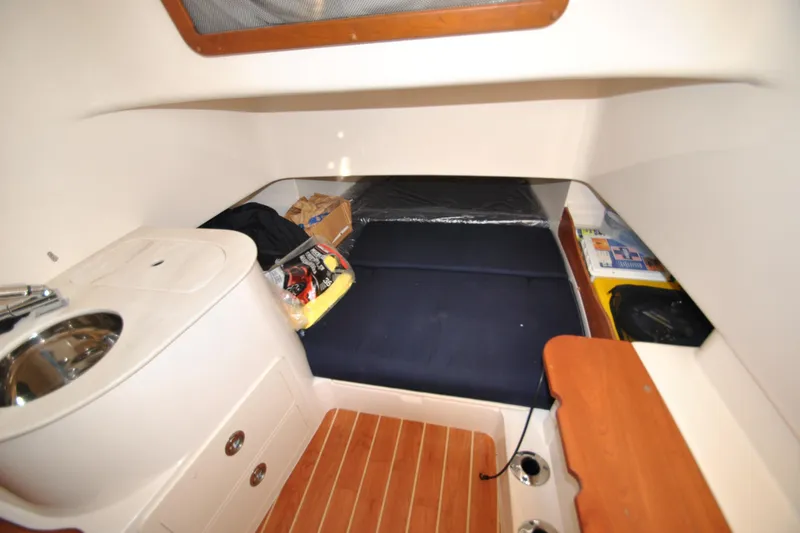 Slide: The Image of 2021 Grady-White Canyon 336 cabin interior with sink, storage, and cozy sleeping area. - 20