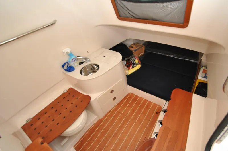 Slide: The Image of 2021 Grady-White Canyon 336 cabin interior with sink, toilet, and seating area. - 21