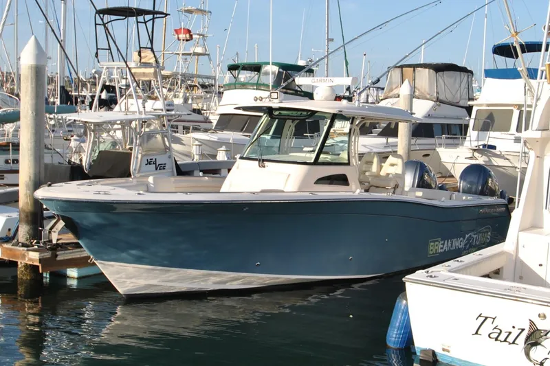 Slide: The Image of 2021 Grady-White Canyon 336 boat docked in a marina, surrounded by other vessels. - 5