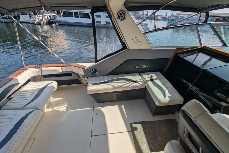 Slide: The Image of 1987 Sea Ray 390 Express Cruiser interior with seating, docked at marina. - 10