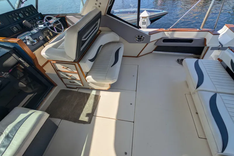 Slide: The Image of 1987 Sea Ray 390 Express Cruiser interior with helm, seating, and water view. - 11