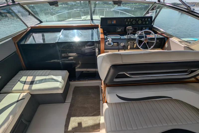 Slide: The Image of 1987 Sea Ray 390 Express Cruiser cockpit with steering wheel and seating, overlooking water. - 12