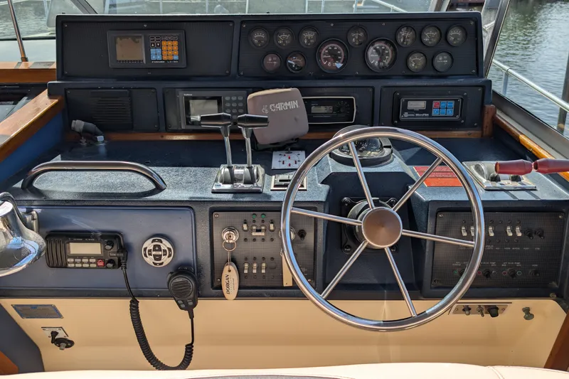 Slide: The Image of 1987 Sea Ray 390 Express Cruiser helm with steering wheel, gauges, and navigation equipment. - 15