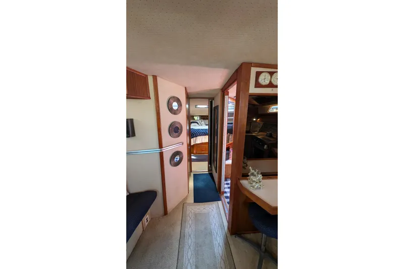 Slide: The Image of Interior of 1987 Sea Ray 390 Express Cruiser with cozy seating and nautical decor. - 17