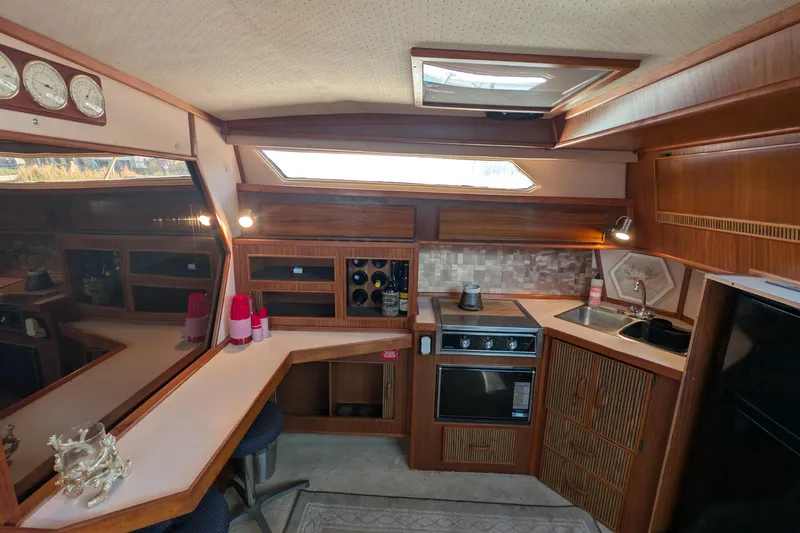 Slide: The Image of Interior of 1987 Sea Ray 390 Express Cruiser with kitchen and seating area. - 19
