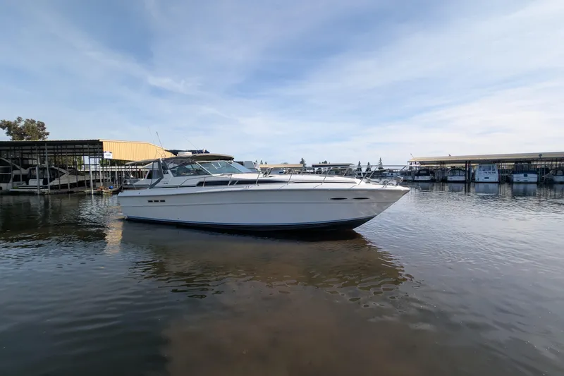 Slide: The Image of 1987 Sea Ray 390 Express Cruiser docked at marina under clear sky. - 2