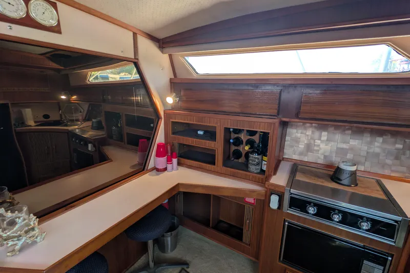 Slide: The Image of Interior of 1987 Sea Ray 390 Express Cruiser with kitchen and seating area. - 21