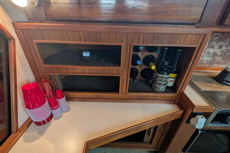 Slide: The Image of 1987 Sea Ray 390 Express Cruiser interior with wine rack and red cups on counter. - 22