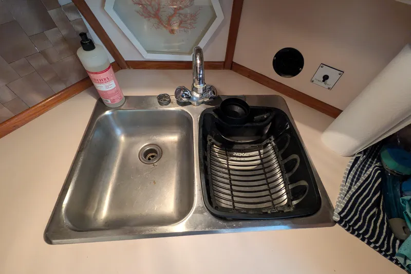 Slide: The Image of Stainless steel sink in 1987 Sea Ray 390 Express Cruiser galley with dish rack and soap. - 27