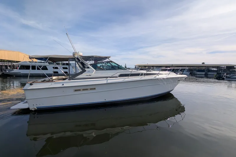 Slide: The Image of 1987 Sea Ray 390 Express Cruiser docked at marina under clear sky. - 3