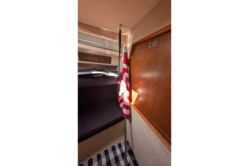 Slide: The Image of Interior of 1987 Sea Ray 390 Express Cruiser with American flag and wooden paneling. - 30