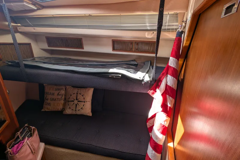 Slide: The Image of 1987 Sea Ray 390 Express Cruiser cabin interior with bunk beds and American flag. - 32