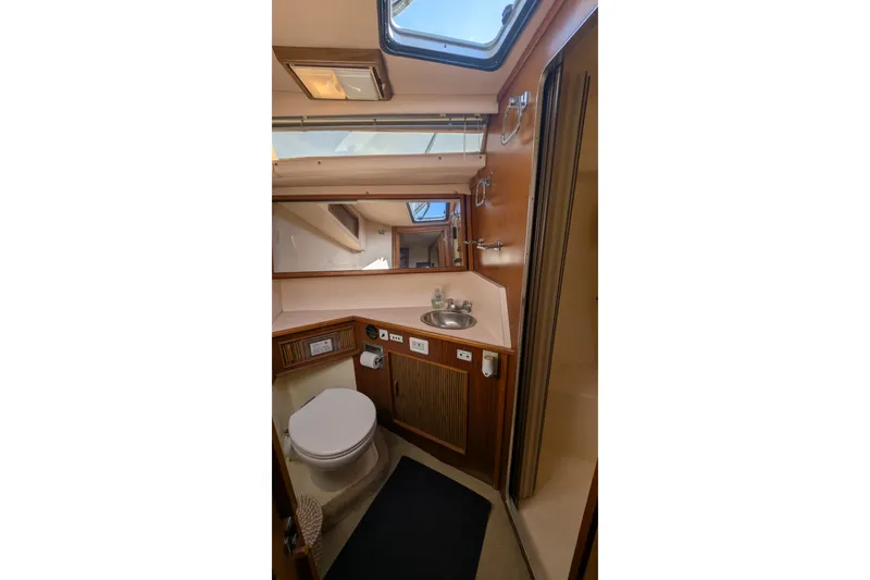 Slide: The Image of 1987 Sea Ray 390 Express Cruiser bathroom with skylight, sink, and toilet. - 33