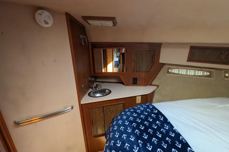 Slide: The Image of 1987 Sea Ray 390 Express Cruiser cabin interior with sink and bed. - 37