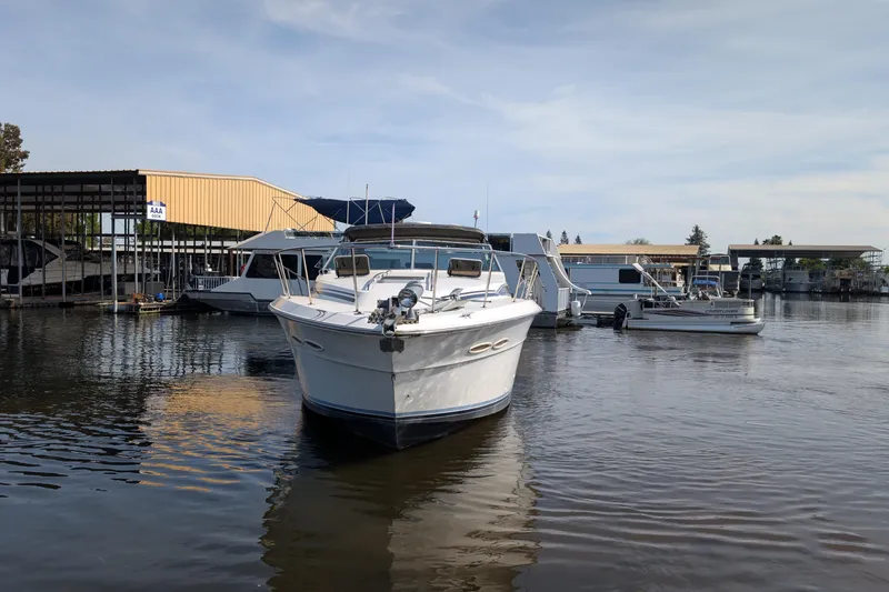Slide: The Image of 1987 Sea Ray 390 Express Cruiser docked at marina, surrounded by other boats. - 4