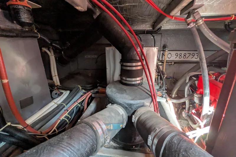 Slide: The Image of Engine room of a 1987 Sea Ray 390 Express Cruiser with visible hoses and wiring. - 48